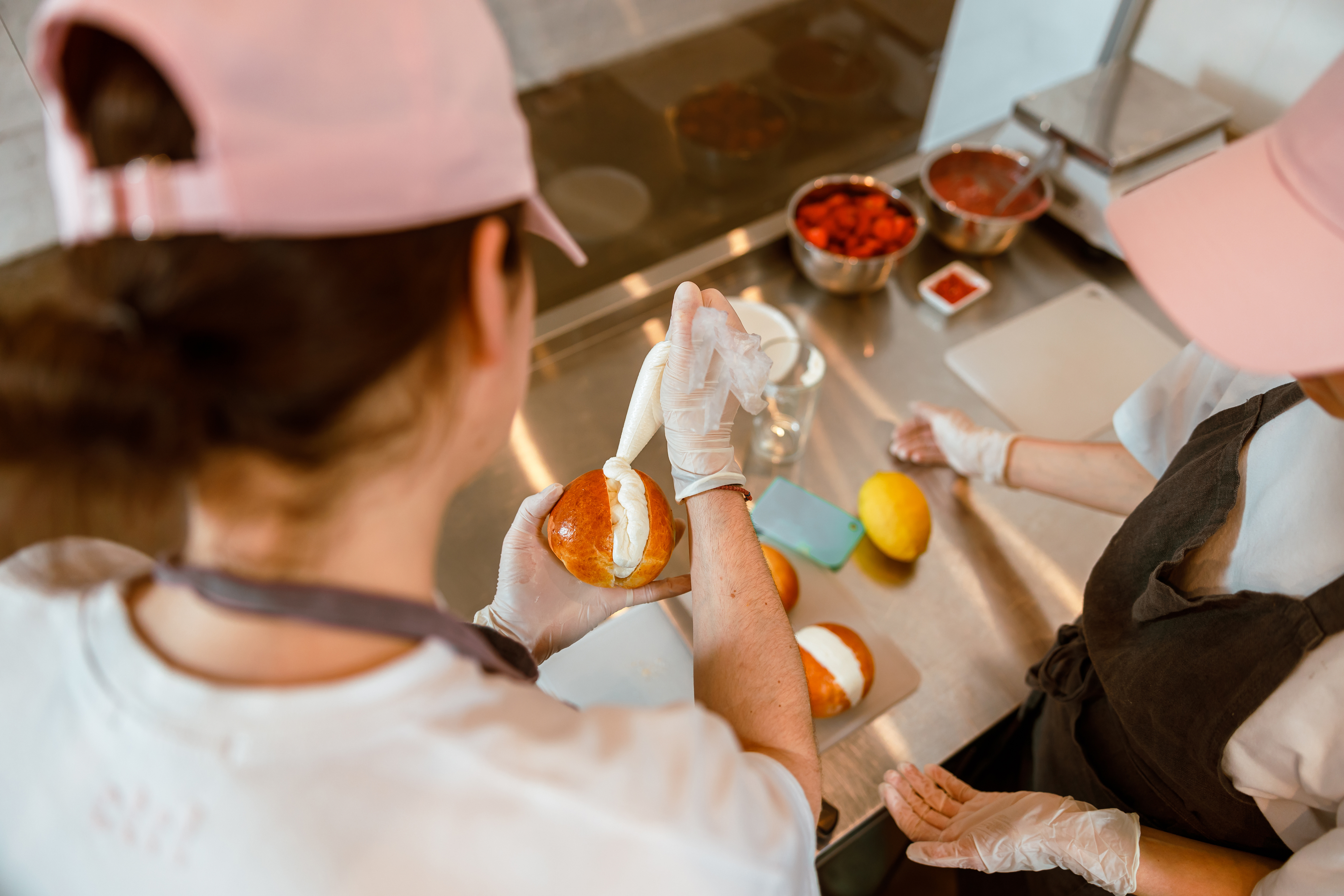Persona poniendo crema en un pan